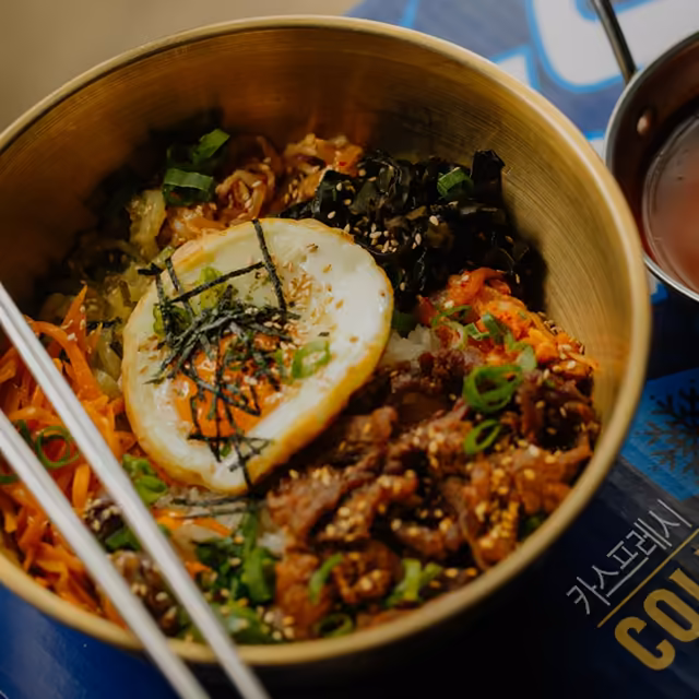 Bibimbap w złotej misce z jajkiem sadzonym