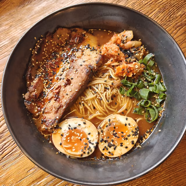 Ramen w ciemnej misce z żeberkiem i jajkiem